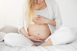 blonde pregnant woman looking her belly supporting it with her hands waiting her baby boy woman come (1)